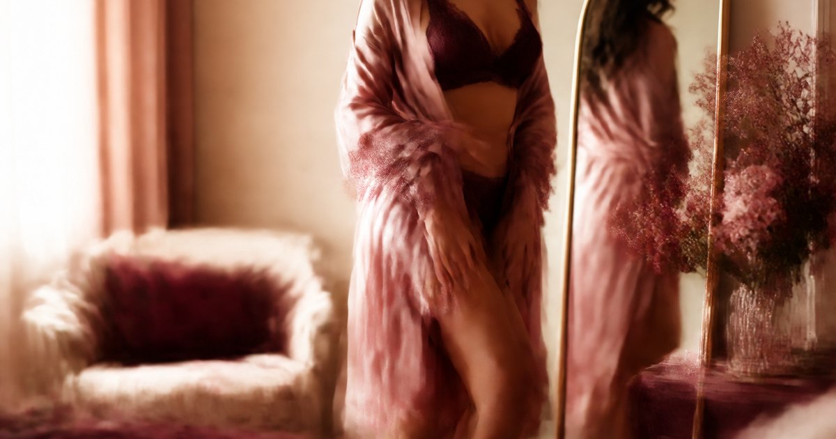 Pessoa escolhendo lingerie diante de um espelho em um ambiente íntimo e acolhedor
